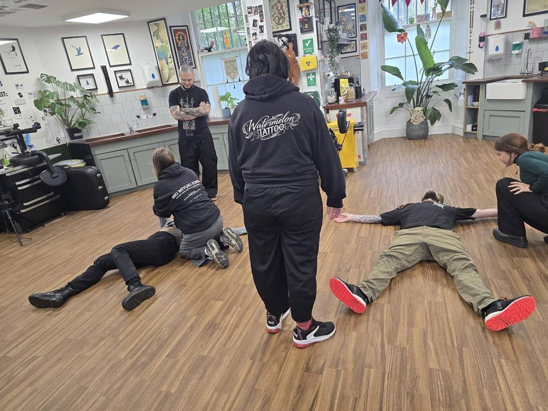 Delegates practising the recovery position and casualty care during on-site first aid training