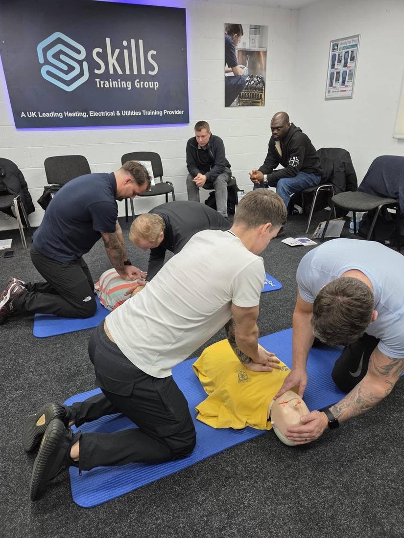 Two delegates practising CPR on a manikin during a workplace first aid course